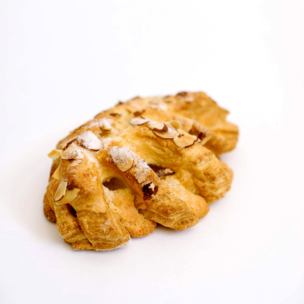 Danish Pastry Bear Claw, filled with almond paste and topped with slivered almonds and sugar. Also written as bearclaws, this breakfast delight is a favorite on it's own or with coffee.