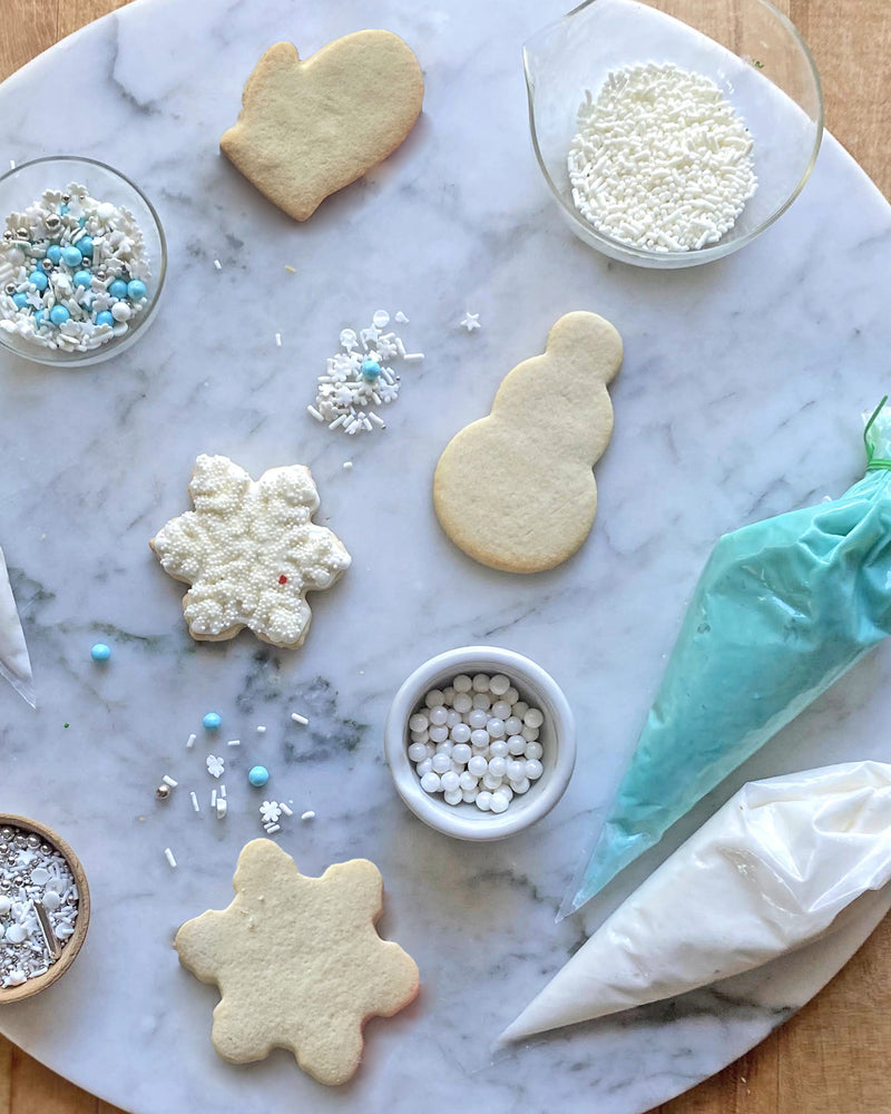 Mitten, snowman, and snowflake cookies, to decorate with icing and sprinkles, for a snowy Cookie Decorating Kit.
